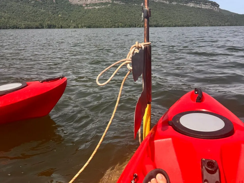Kayaking past a marker on a mountain lake
